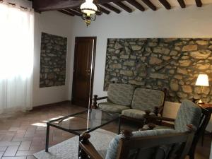 a living room with two chairs and a glass table at Podere La Cerraia in Serravalle Pistoiese