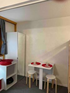 mały biały stół i dwa stołki w pokoju w obiekcie Studio skis au pieds Meribel-Mottaret w mieście Les Allues