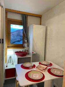 a kitchen with a table with two plates and a window at Studio skis au pieds Meribel-Mottaret in Les Allues
