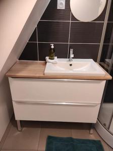 La salle de bains est pourvue d'un lavabo blanc et d'un escalier. dans l'établissement Gîte Mont Saint Michel Beauvoir, à Beauvoir
