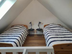 Cette chambre mansardée dispose de 2 lits et d'une juponmottermott. dans l'établissement Gîte Mont Saint Michel Beauvoir, à Beauvoir