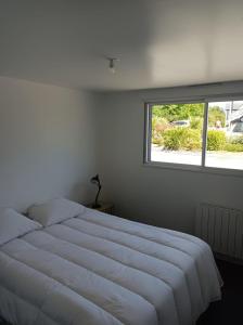- un lit blanc dans une chambre avec fenêtre dans l'établissement Gîte Mont Saint Michel Beauvoir, à Beauvoir