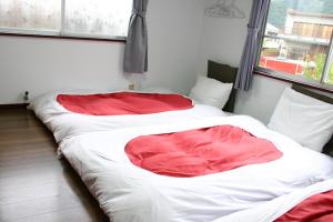 two beds in a room with red and white sheets at RETRO retro - Vacation STAY 96287v in Azagawa