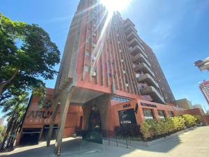 um edifício alto com o sol brilhando sobre ele em Aruá Hotel em Presidente Prudente