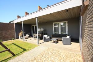 a covered patio with a couch and chairs at Our House in Breskens