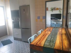 cocina con mesa de madera y nevera en La Casona de Alba, en Encinasola