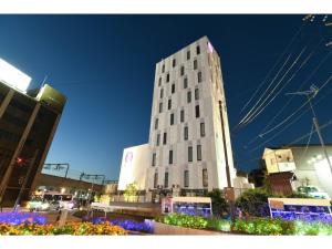 een hoog wit gebouw met bloemen ervoor bij Hotel Wisteria NARA - Vacation STAY 99245v in Nara