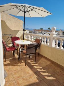 d'une table, de chaises et d'un parasol sur le balcon. dans l'établissement Monte Mar Apartment, à Gran Alacant