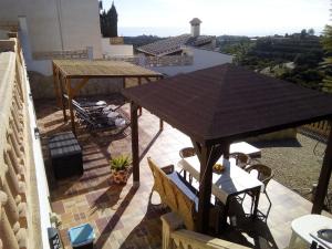 a patio with a table and chairs on a roof at Casa rural CAÑADA PAEZ in Vélez-Málaga +20 photos