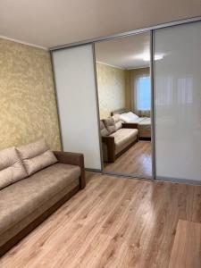 a living room with a couch and a mirror at Kärberi Apartments in Tallinn