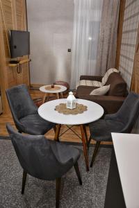 a living room with a table and chairs and a couch at WILD BEAUTY Apartment-Modern mountain 2 in Kolašin