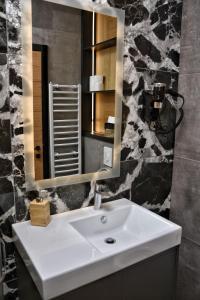 a bathroom with a white sink and a mirror at WILD BEAUTY Apartment-Modern mountain 2 in Kolašin