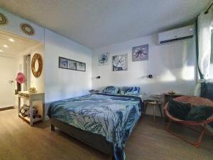 a bedroom with a bed and a table and a chair at Studio TY SOLEY in Saint-François