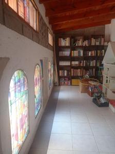una habitación con vidrieras y estanterías de libros en Hermosa casa con parque en Córdoba