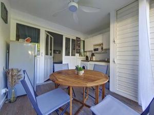 a small kitchen with a wooden table and chairs at Studio TY SOLEY in Saint-François