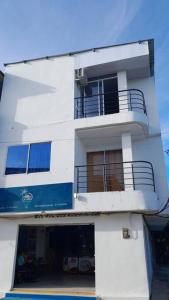 a white building with a balcony on the side of it at Apartamento Esmeralda Arboletes in Arboletes