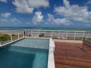 una piscina en un balcón con la playa en Paradise Beach Flat's, en João Pessoa