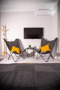 2 Stühle und ein Tisch in einem Zimmer mit einem TV in der Unterkunft Casa Rural - Apartments 4 you - La Nucia in La Nucía