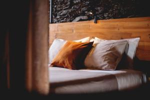 1 cama con almohadas blancas y cabecero de madera en Porto Natura Loft en Valongo