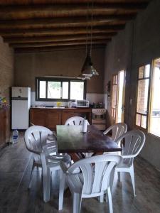 uma cozinha com uma mesa de madeira e cadeiras brancas em Casa Grande Reservas por privado em San Javier