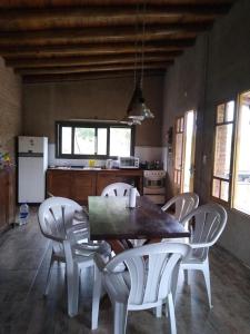 a kitchen with a wooden table and white chairs at Casa Grande Reservas por privado in San Javier
