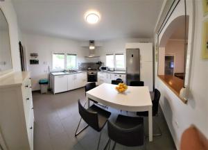 a kitchen with a white table and chairs at Seaview Chalet in Arafo