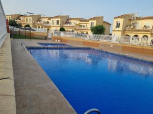 une grande piscine bleue avec des bâtiments en arrière-plan dans l'établissement Monte Mar Apartment, à Gran Alacant