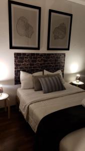 a bedroom with a large bed and a brick wall at Pacific Spot San Miguel in Lima