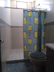 łazienka z zasłoną prysznicową i toaletą w obiekcie Casa de Alexita w mieście Puerto Baquerizo Moreno