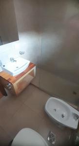 y baño con aseo blanco y lavamanos. en Edificio Calderon UF33 en San Martín de los Andes