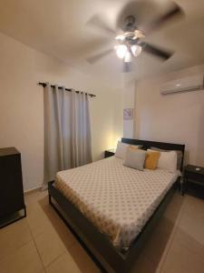 - une chambre avec un lit et un ventilateur de plafond dans l'établissement Amplio apartmento, à Saint-Domingue
