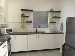 a kitchen with white cabinets and a sink at Overnight stay. Self-catering. in Klerksdorp