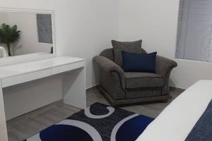 - un salon avec une chaise et un tapis dans l'établissement Overnight stay. Self-catering., à Klerksdorp