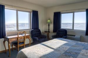 a bedroom with a bed and two chairs and a desk at Lighthouse Inn - Two Rivers in Two Rivers