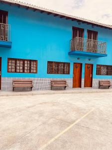 a blue building with benches in a parking lot at Residencial Albatroz in Caraguatatuba