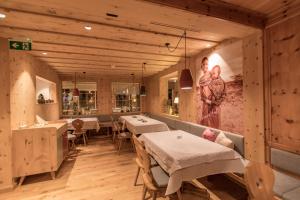 a restaurant with tables and a picture on the wall at Hotel Sportalmmm, Hoch-Genuss in Zauchensee