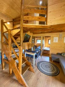 Cabaña de madera con cama elevada y sala de estar en Siedlisko Pod Pucharami, en Hoczew