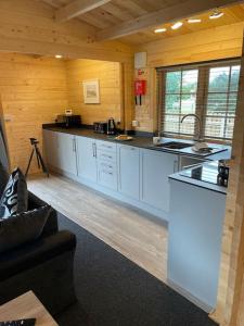 a kitchen with white counter tops in a cabin at Hulver Lodge, Snape, Suffolk. in Snape