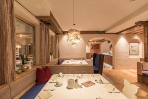 een restaurant met 2 tafels en een kroonluchter bij Hotel Sportalmmm, Hoch-Genuss in Zauchensee