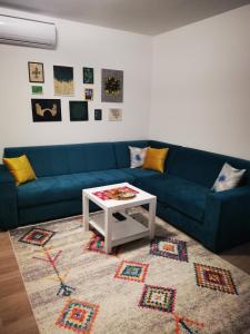 ein Wohnzimmer mit einem blauen Sofa und einem Tisch in der Unterkunft Apartman Dream House in Mostar