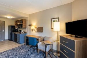 a hotel room with a desk and a flat screen tv at Candlewood Suites - Bluffton-Hilton Head, an IHG Hotel in Bluffton