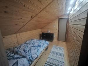 a bedroom with a bed in a wooden room at Siedlisko Pod Pucharami in Hoczew
