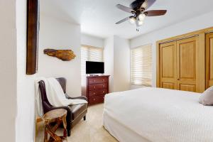 a bedroom with a bed and a tv and a chair at Hidden Creek Retreat in Park City