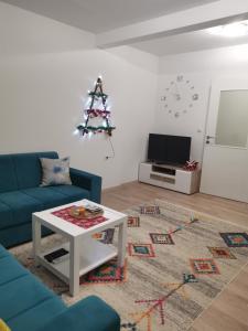 ein Wohnzimmer mit einem blauen Sofa und einem Tisch in der Unterkunft Apartman Dream House in Mostar