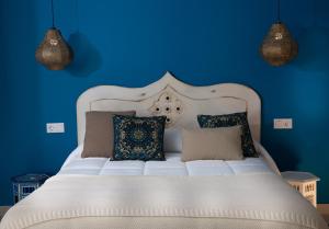 Dormitorio azul con cama blanca y almohadas en La Camareta Alojamientos Turísticos Rurales, 