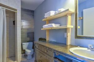 a bathroom with a sink and a toilet and a mirror at Auberge de Jeunesse Le Camp De Base in LʼAnse-Saint-Jean