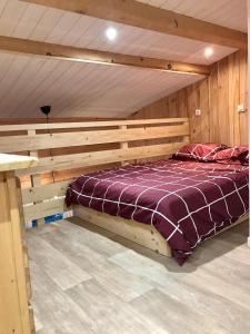 Cama grande en habitación con paredes de madera en appartement ski au pied, en Les Deux Alpes