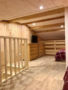 Habitación grande con paredes revestidas de madera y TV. en appartement ski au pied, en Les Deux Alpes