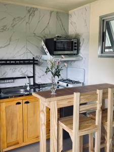 cocina con mesa y microondas en Altos de Kiyu, en José Ignacio 1 foto más