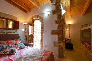 una camera con un letto in una stanza con un muro in pietra di Affascinante Grande Liama Antica a Salve